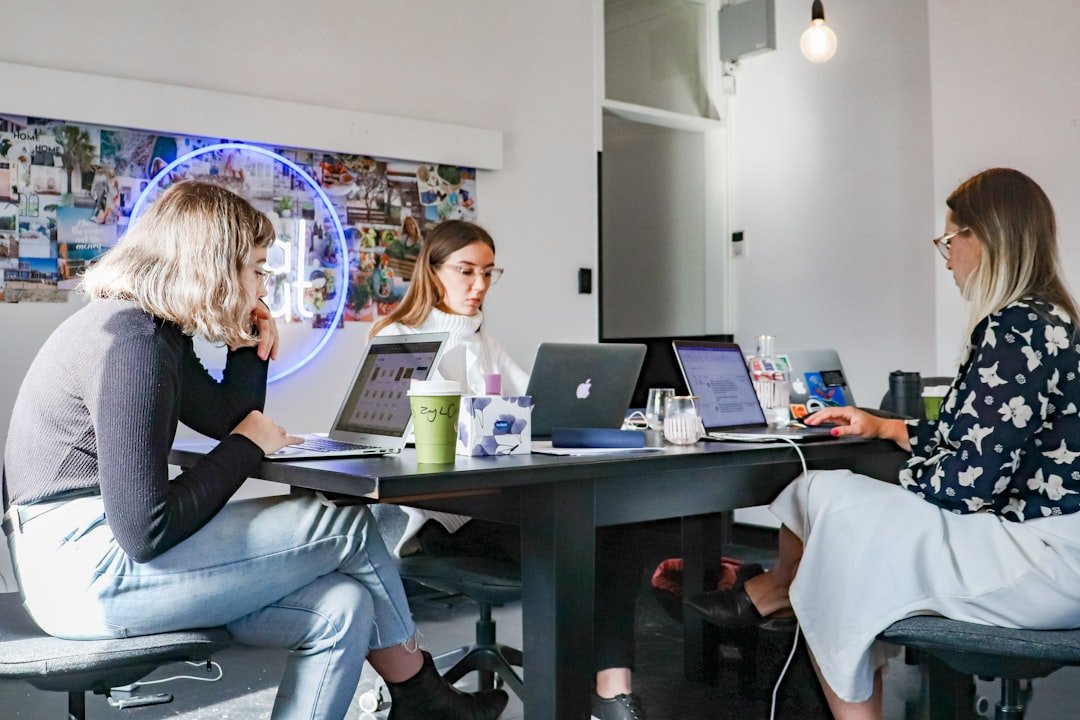 3-women-sitting-on-chair-in-front-of-table-with-laptop-computers-r0saaqnjejq